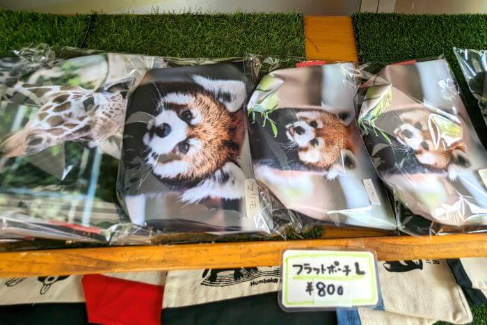 福岡市動物園のこども動物園食堂横で販売されているフラットポーチの画像。福岡市動物園で実際に飼育されているレッサーパンダとキリンがプリントされている